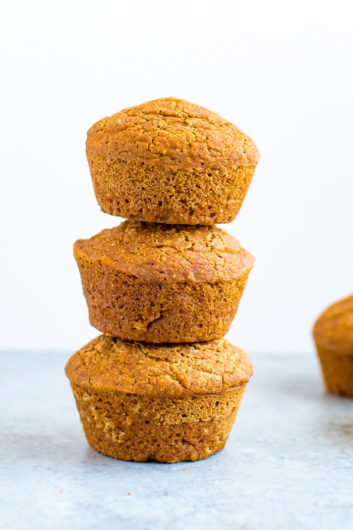 Stack of 3 healthy pumpkin cornbread muffins.