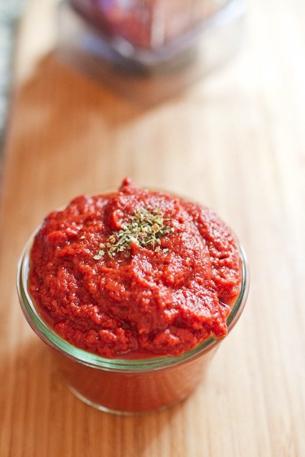 Easy No Cook Blender Pizza Sauce in a weck jar on a cutting board.