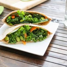 Kale Salad Stuffed Pitas served on a white square plate on wood table.