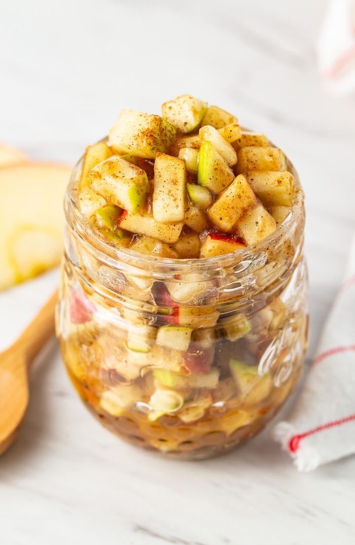 Raw apple pie filling a glass jar.