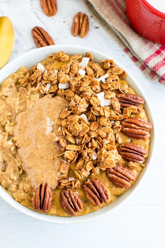 This protein pumpkin oatmeal recipe is loaded with pumpkin flavor and protein. The secret is whipping egg whites into the oats while they cook! Pumpkin protein oatmeal topped with granola, peanut butter, and pecans.