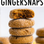 Stack of gingersnap cookies. The top one has a bite taken out of it.