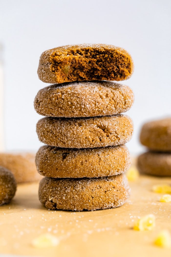 Stack of gingersnap cookies. The top one has a bite taken out of it.