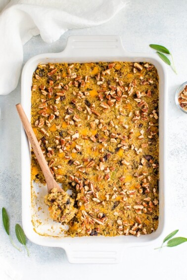 Casserole dish with baked quinoa stuffing topped with pecans.