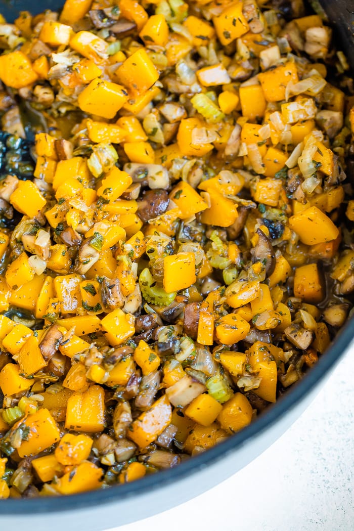 Skillet with mushrooms, butternut squash and celery cooking in the pan.
