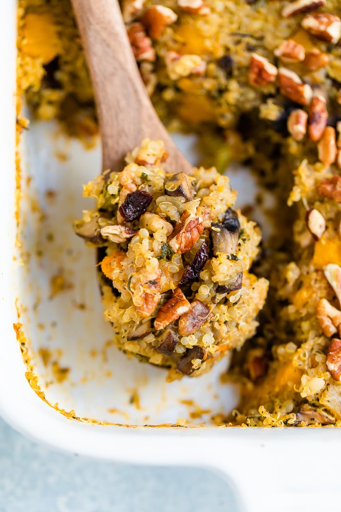 Wood spoon scooping a serving of quinoa stuffing.