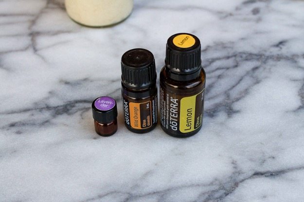 Save this recipe for Homemade Whipped Coconut Oil Sugar Scrub! Three doTerra Essential Oils sitting on a marble countertop.