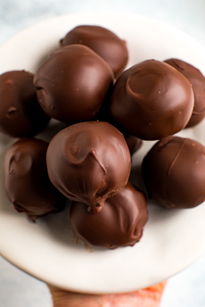 Plate of healthy peanut butter balls coated in chocolate.