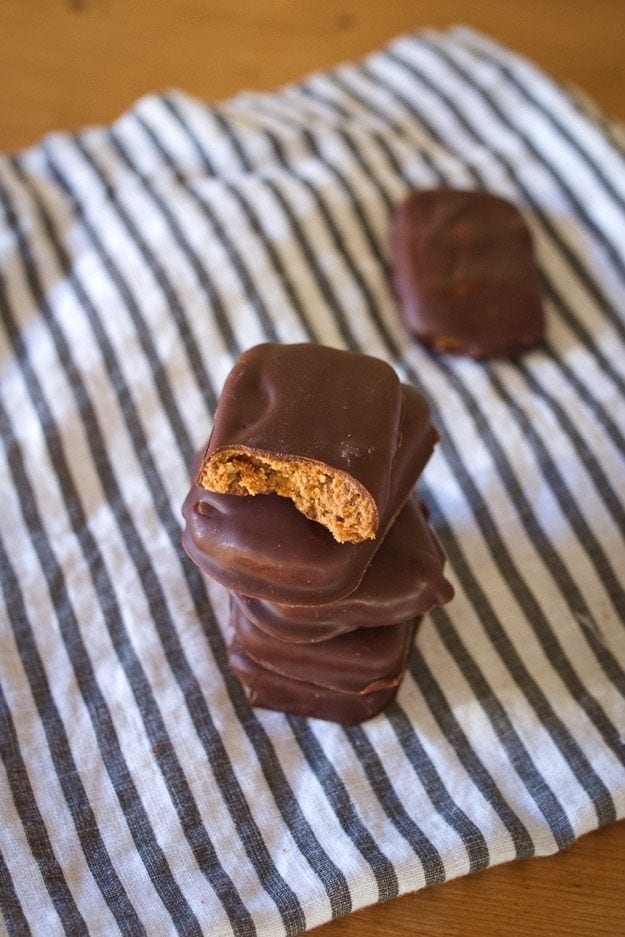Homemade Chunky Almond Butter thinkThin Bars stacked on a striped dish cloth.