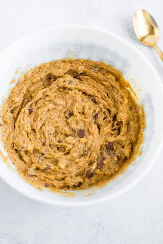 Mixing bowl and spoon with batter for chocolate chip coconut flour banana bread.