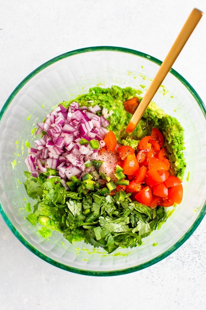 Mixing bowl with the ingredients for pea guacamole.