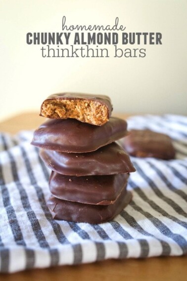 Homemade Chunky Almond Butter thinkThin Bars stacked on a striped dish cloth.