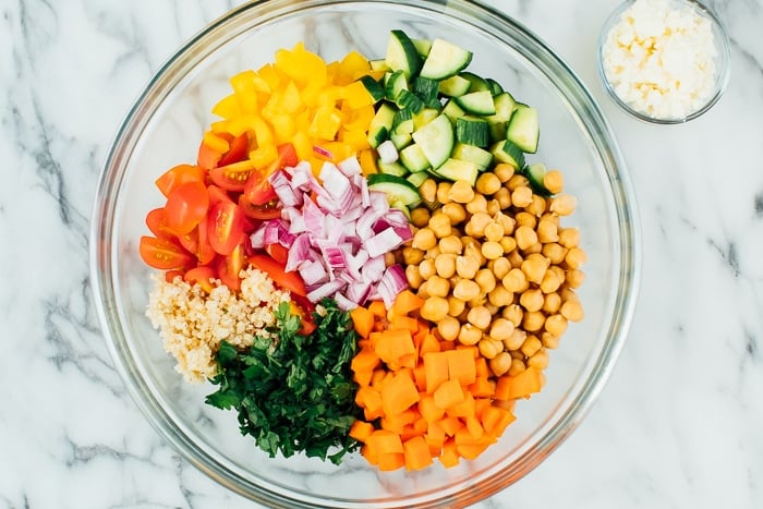 Ingredients for the quinoa chickpea salad in a bowl with feta on the side. 