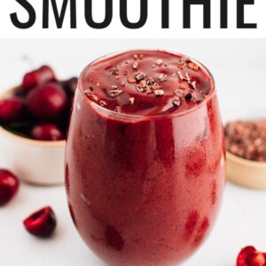 Chocolate cherry smoothie in a glass and topped with cacao nibs.