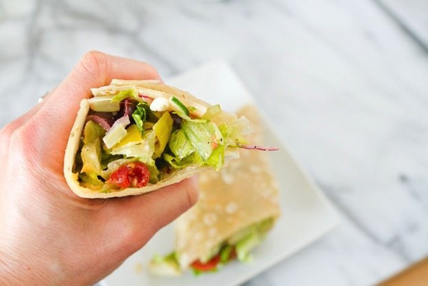 Greek Salad Wrap in hand.