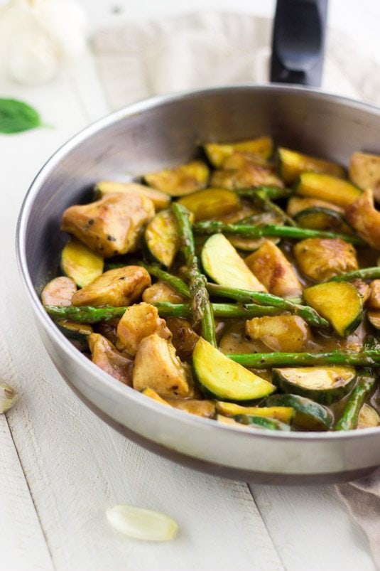 Honey Mustard Chicken Stir Fry in a silver pan on white wood counter