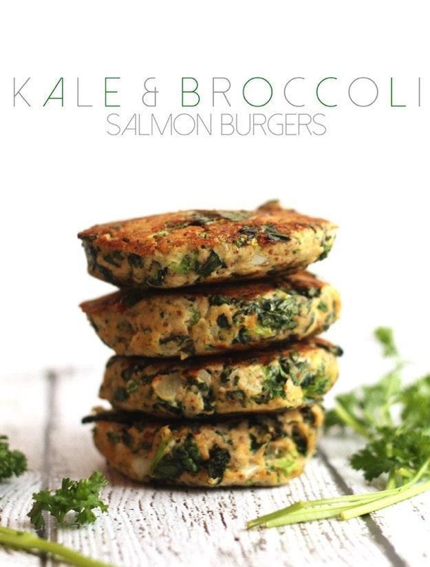 Kale and Broccoli Salmon Burgers stacked on a white table.