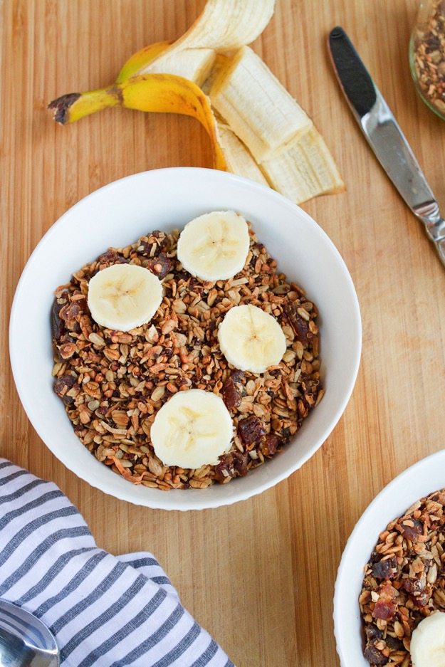 Homemade Gluten-free Cereal with Quinoa Buckwheat & Dates in a bowl. An open banana is next to the bowl.