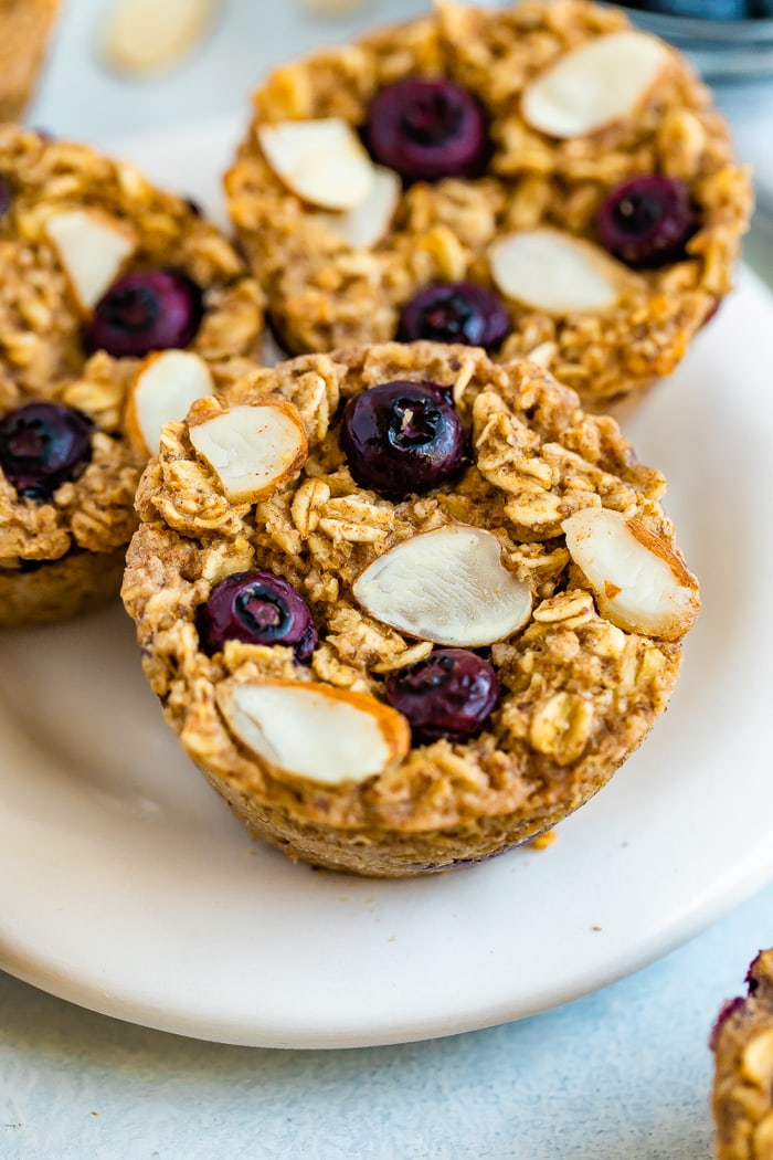 Three blueberry almond baked oatmeal cups on a plate.