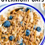 Bowl of overnight oats topped with granola, blueberries and a peanut butter drizzle.