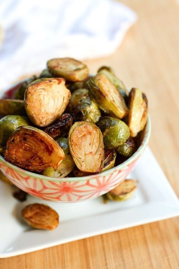 Date sweetened balsamic glazed Brussels sprouts in a decorative serving bowl.