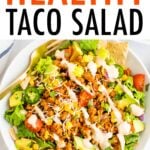 Taco salad topped with ground turkey, avocado, corn, peppers, chips, dressing and tomatoes.