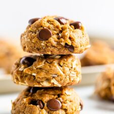Stack of three chocolate chip peanut butter oatmeal cookies with coconut.