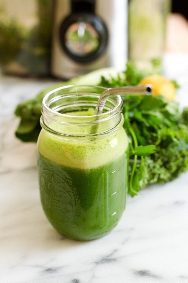 Green juice in a mason jar with stainless steal straw. 