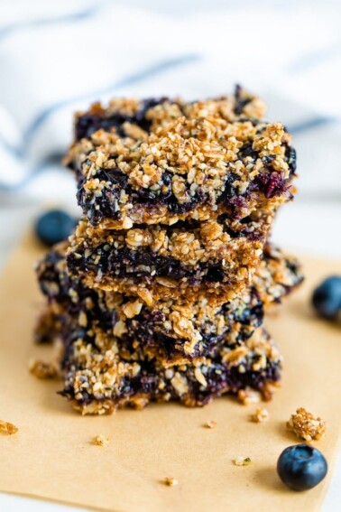 Stack of four blueberry crumble bars with an oat and hemp seed crumble topping.