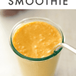 Pumpkin pie smoothie in a glass with a metal straw.