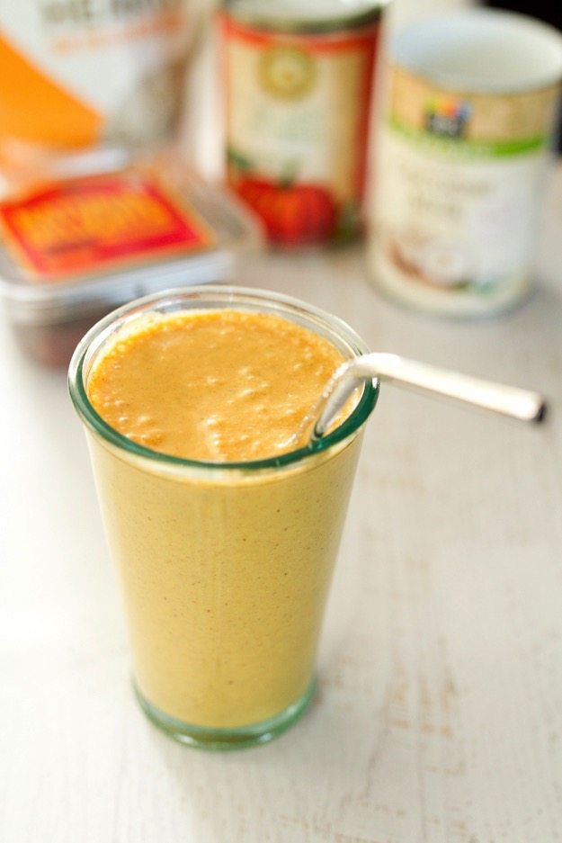 Pumpkin pie smoothie in a glass with a straw.