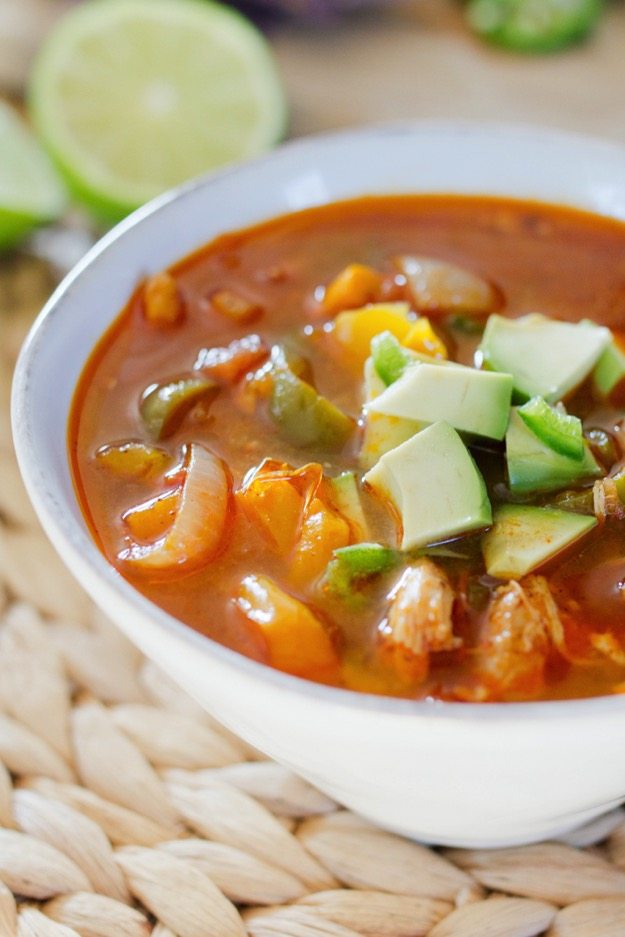 Gluten free and paleo slow cooker chicken fajita soup. Made with chicken, pepper and onions. Topped with avocado.