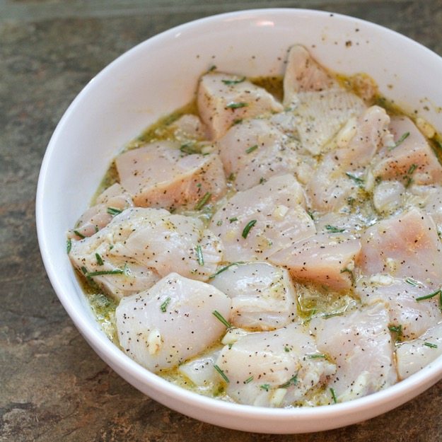 Marinating Rosemary Chicken in a shallow bowl.