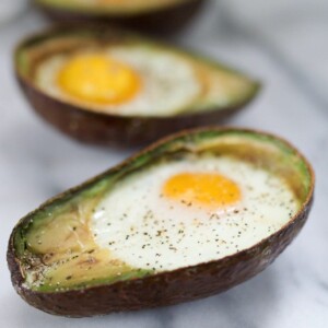 An avocado cut in half with an egg baked inside.