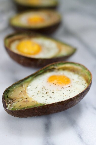 An avocado cut in half with an egg baked inside.