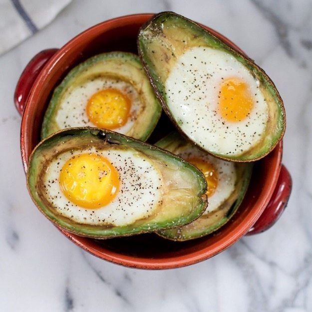 Baked Avocado Eggs in a red dish.