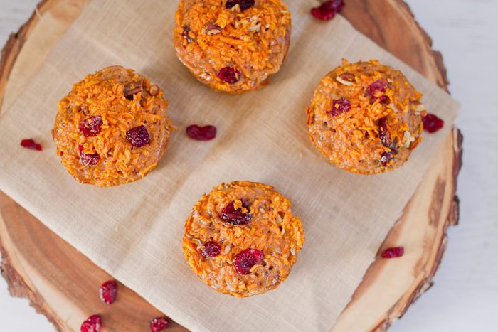 Overhead shot of four muffins served on a wooden charger.