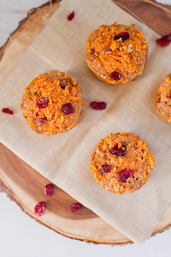 Overhead shot of 4 muffins with cranberries sprinkled around.