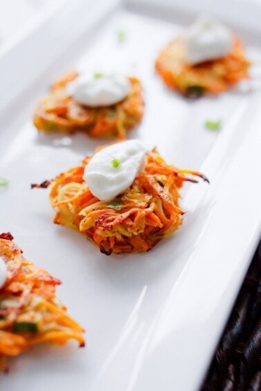 A close up of Sweet Potato and Parsnip Spiralized Latkes on a serving platter.