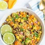 Bowl of quinoa salad with corn, sweet potatoes, corn, cilantro, and black beans.