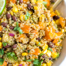 Bowl of quinoa salad with corn, sweet potatoes, corn, cilantro, and black beans.