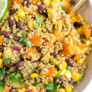 Bowl of quinoa salad with corn, sweet potatoes, corn, cilantro, and black beans.
