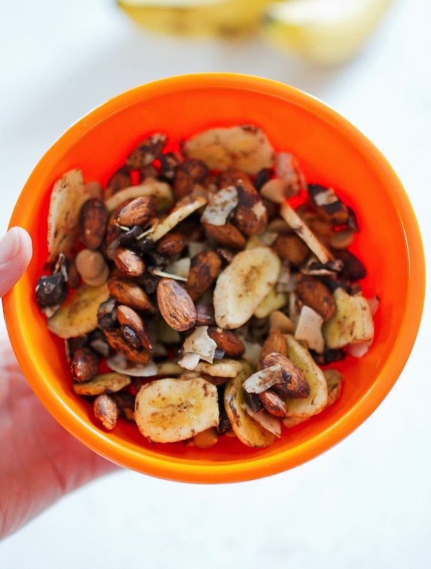 Trail mix with banana chips, chocolate, coconut, and almonds in a bowl.