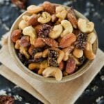 Pizza Trail Mix in a bowl, on top of a folded cloth napkin. Trail mix make from mixed nuts and dried tomatoes with seasoning.