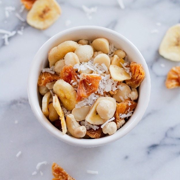Take a trip to the tropics with this island-inspired tropical trail mix with cashews, macadamia nuts, banana chips, dried pineapple and coconut.