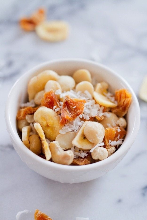 Take a trip to the tropics with this island-inspired tropical trail mix with cashews, macadamia nuts, banana chips, dried pineapple and coconut.