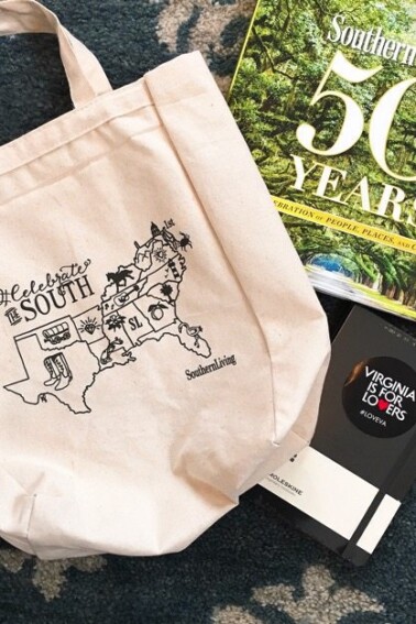 Tote bag that reads "celebrate the south", book titled Souther Living 50 Years, and a moleskin notebook with a sticker reading Virginia is for lovers, all sitting on the carpet.