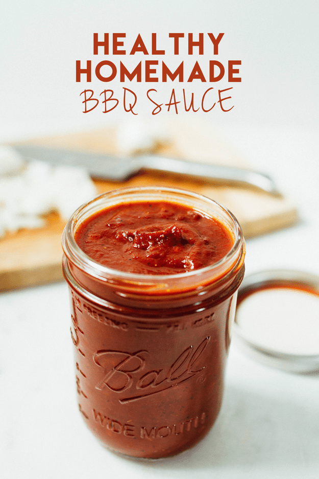 Healthy Homemade BBQ Sauce in a glass jar. Cutting board with knife in the background. 