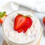 Top of a jar of strawberry overnight oats topped with strawberries.