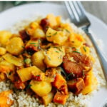 Root vegetable tagine with rosemary and apricots served over a plate of brown rice.